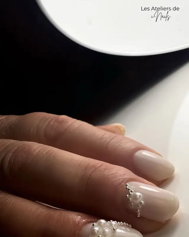 Ongles beige rosé ornés d’une arabesque de perles